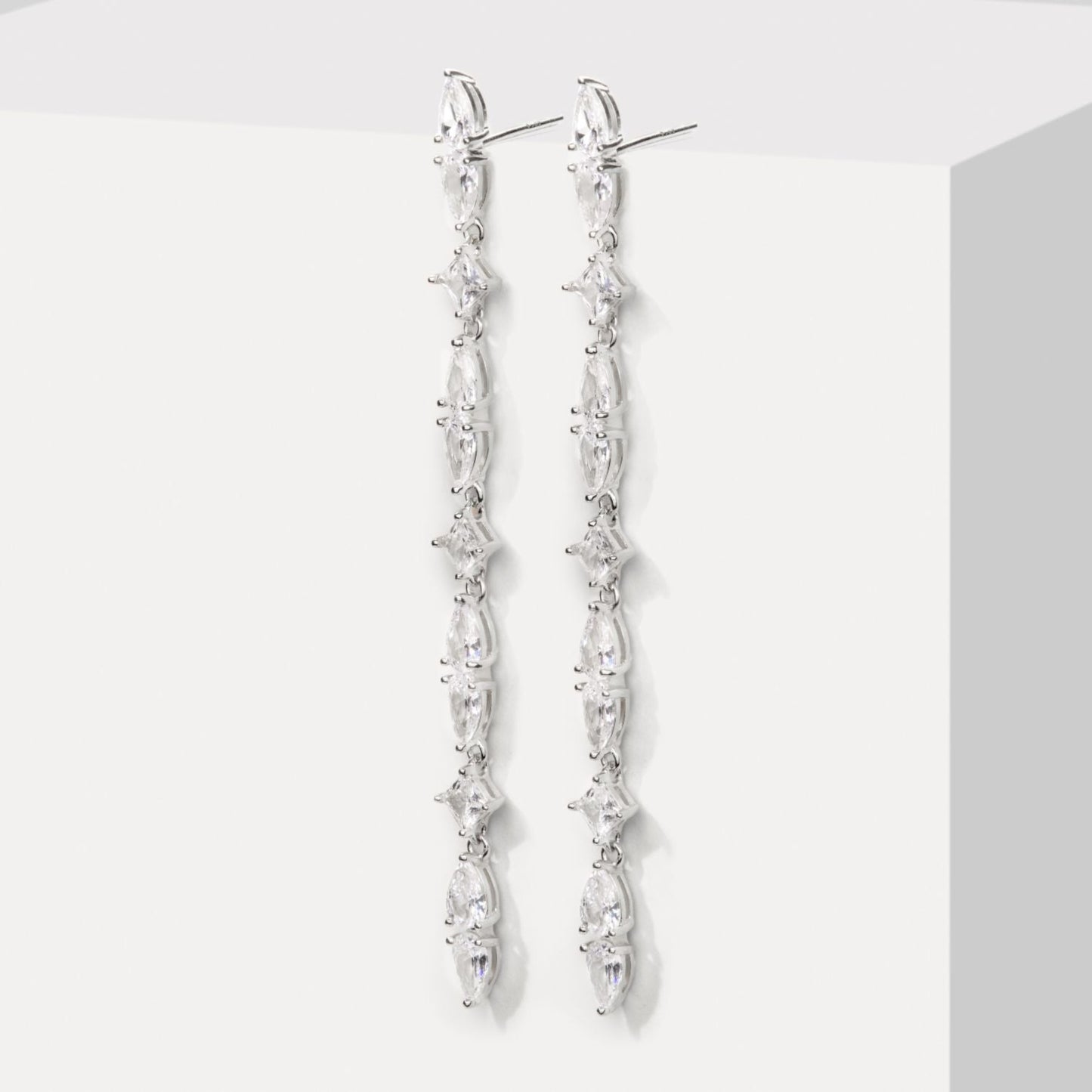 Silver earrings with clear stones on a white background