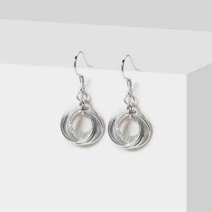 Silver dangle earrings with layered ring charms and hook backs, pair