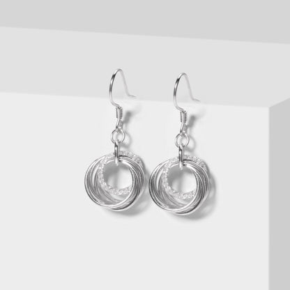 Silver hoop earrings with layered ring swirl drops