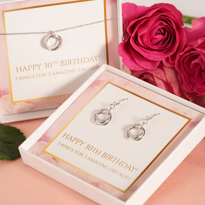 Silver ring pendant drop earrings with linked circles, shown in gift display