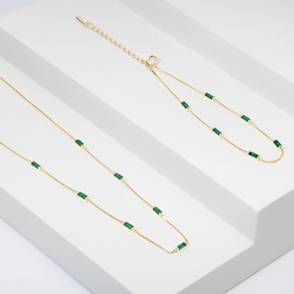 Gold-tone CZ baguette necklace with emerald green rectangular stones on link chain
