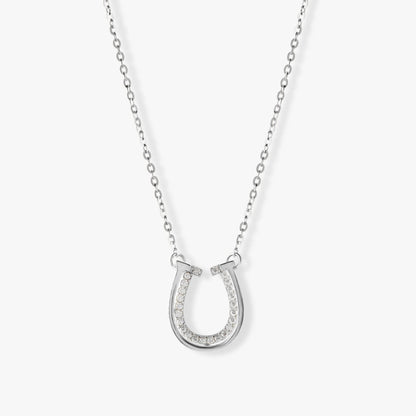 Silver horseshoe pendant necklace with pavé stones and double U-shaped charm details.