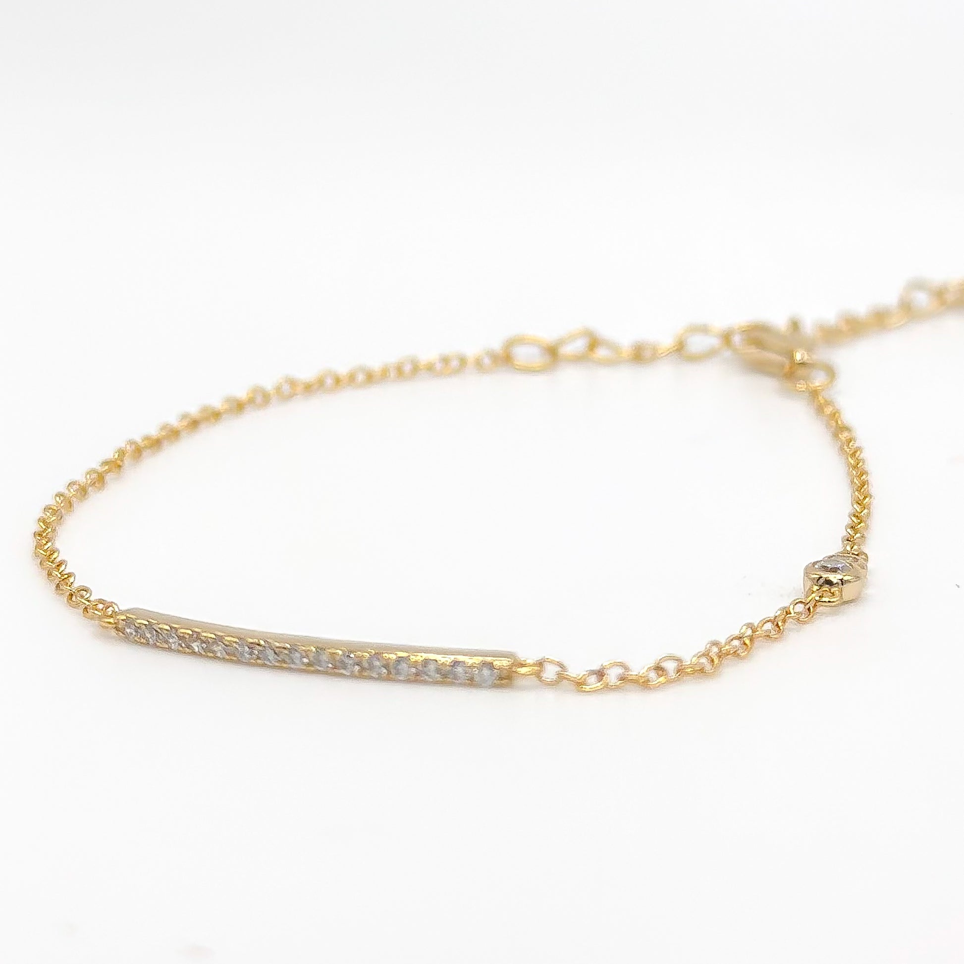 Gold-tone beaded bracelet with slim clear stone bar