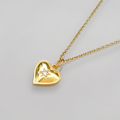Gold vermeil heart pendant close-up with star detail on gold chain