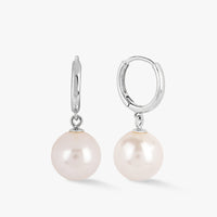 Silver huggie hoop earrings with hanging white pearl drops