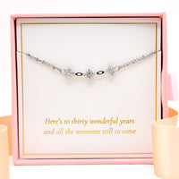 Silver bracelet with three star charms and small black accents