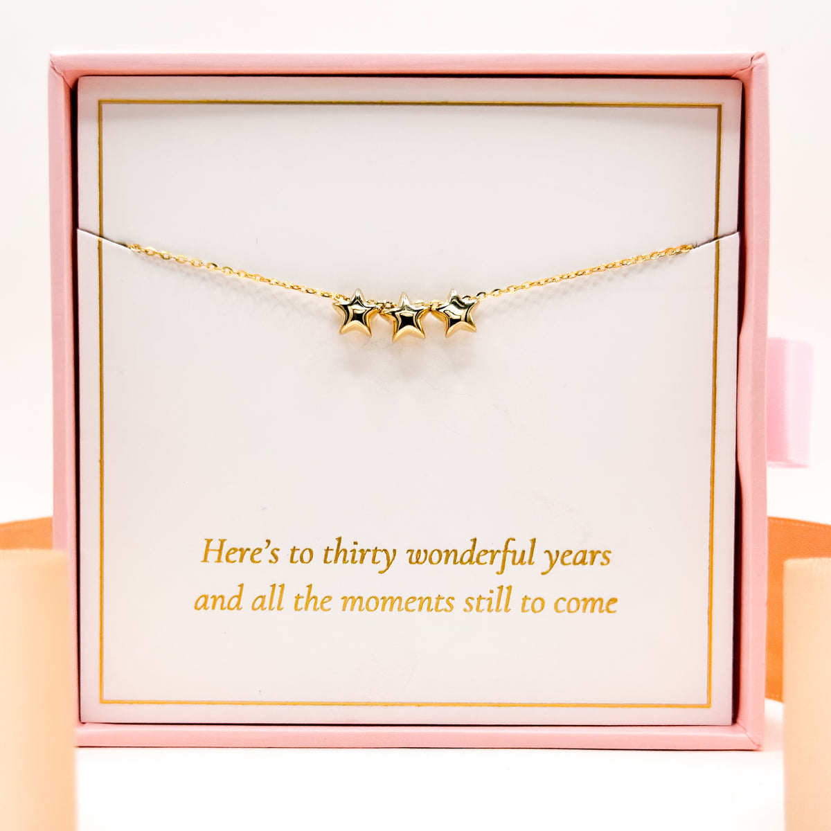 Gold star necklace with three small dangling star charms on a thin chain