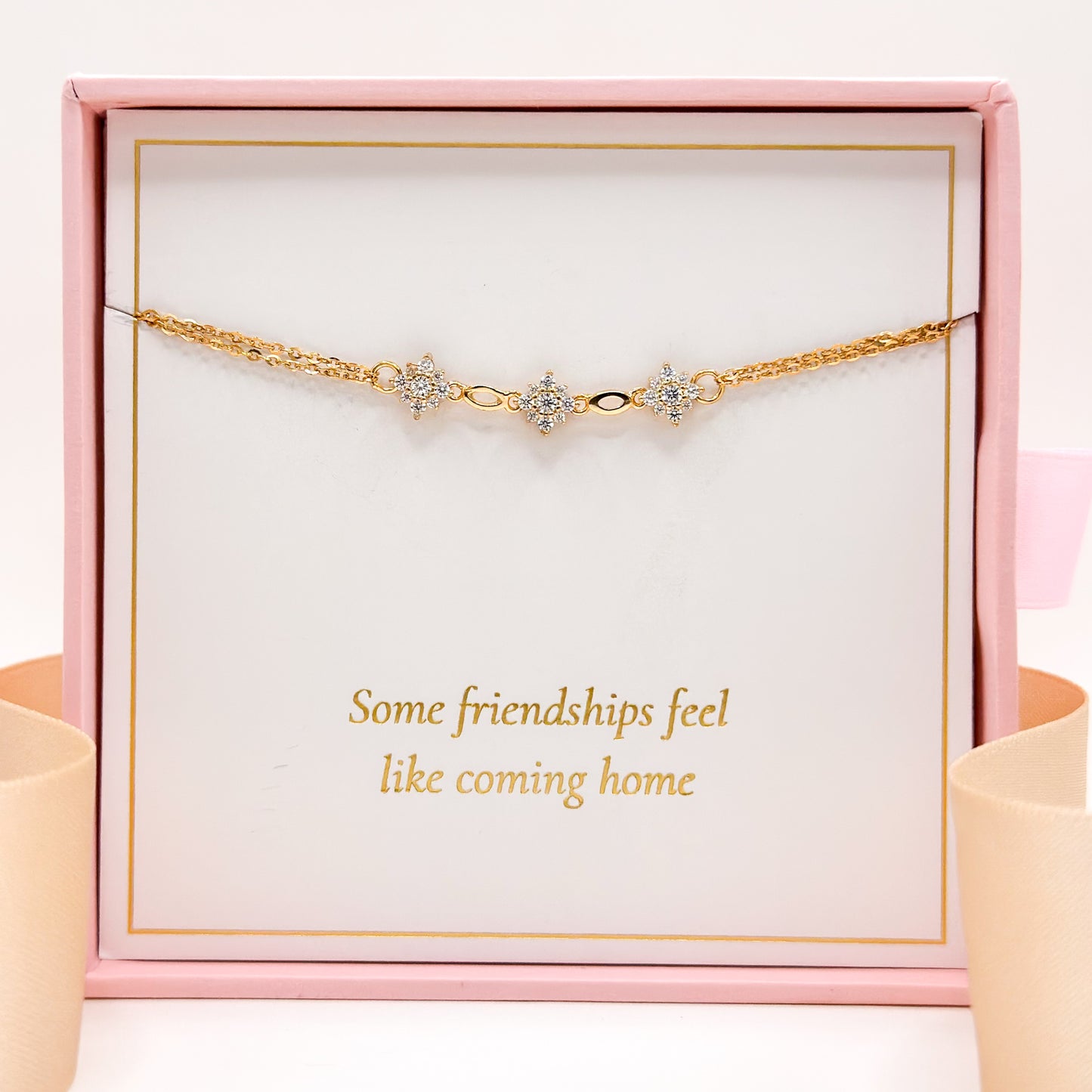 Gold-tone friendship bracelet with three star charms and small clear stones