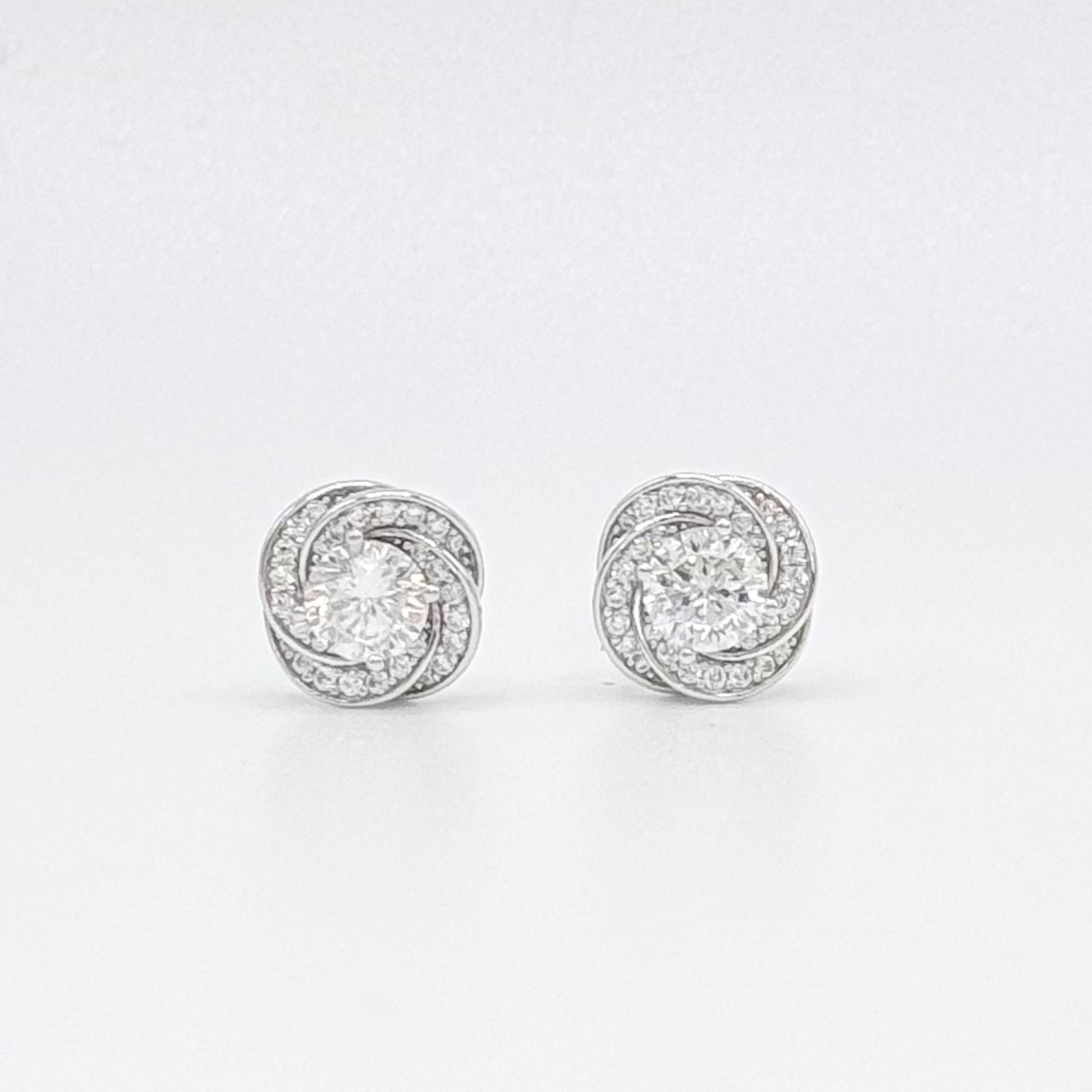 Floral moissanite stud earrings with round center stones in a halo, silver-tone