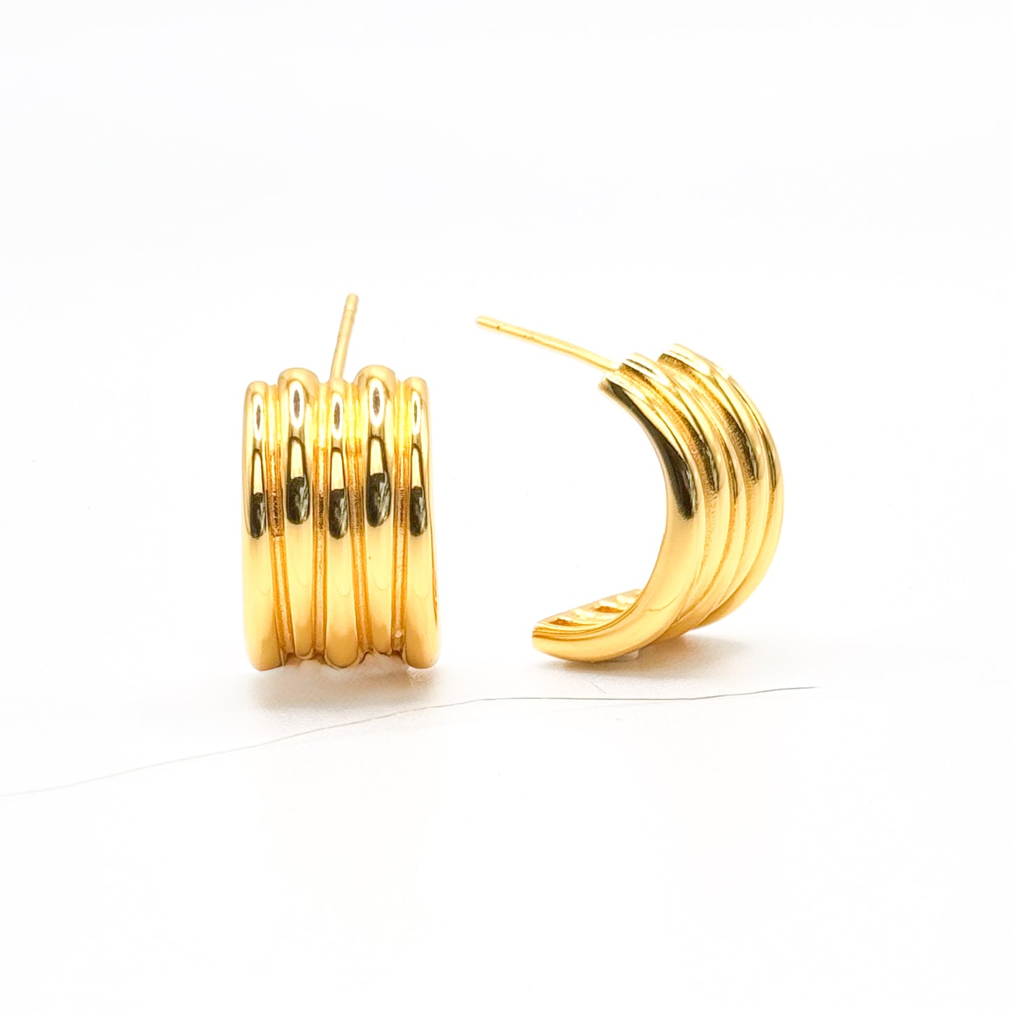 Gold-tone chunky half hoop earrings with ribbed stacked bands, pair view