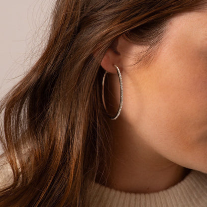 Large hoop earrings with sparkling pavé diamonds on ear