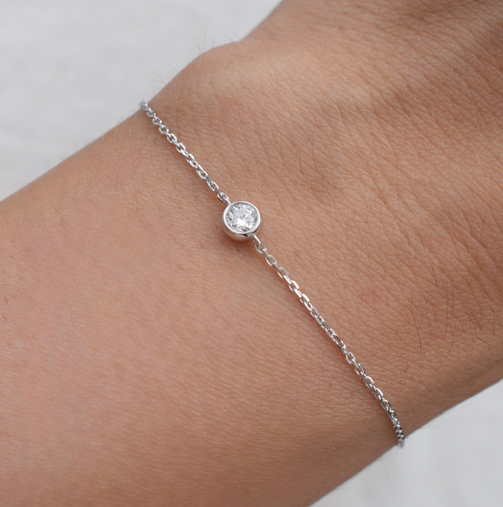 Moissanite bracelet on wrist with round white stone and silver link chain