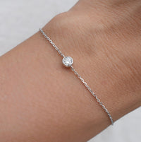 Moissanite bracelet on wrist with round white stone and silver link chain