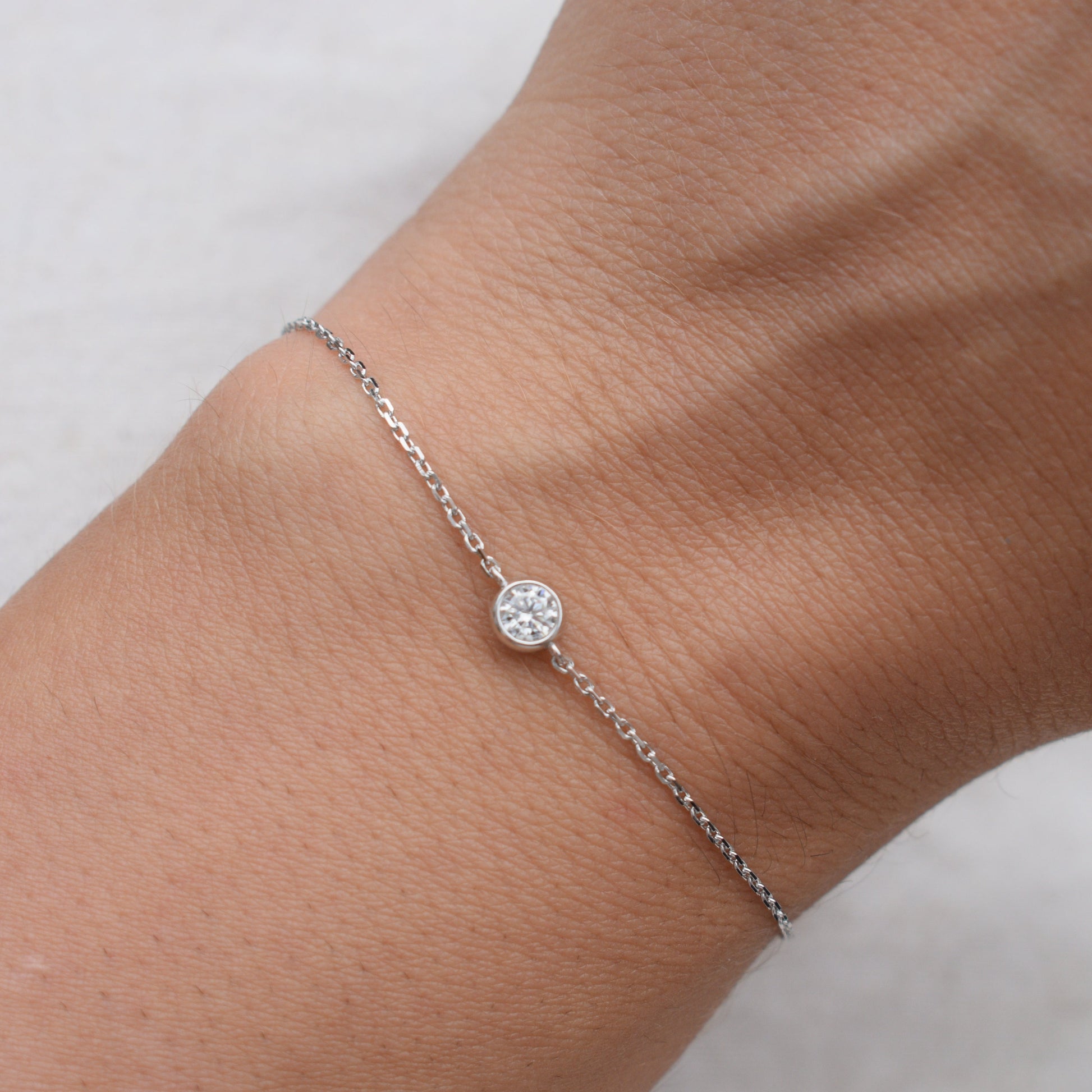 Moissanite bracelet on wrist with sparkling round stone and silver links