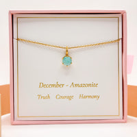 Gold necklace with round blue-green gemstone pendant on fine chain