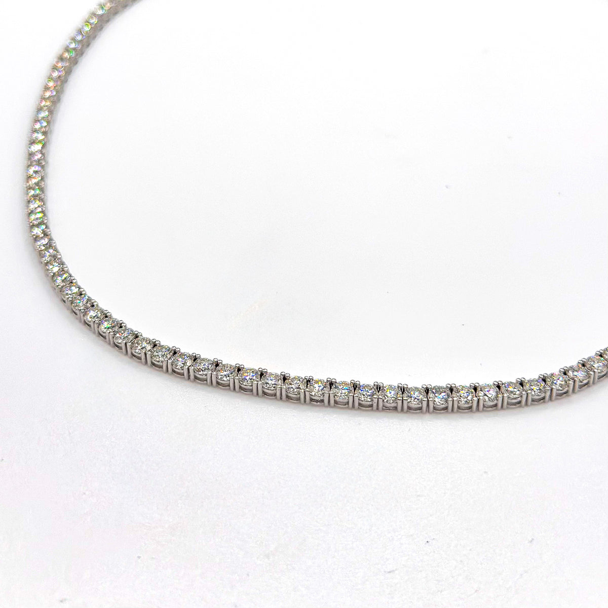 Tennis necklace with round moissanite stones in a silver-toned setting