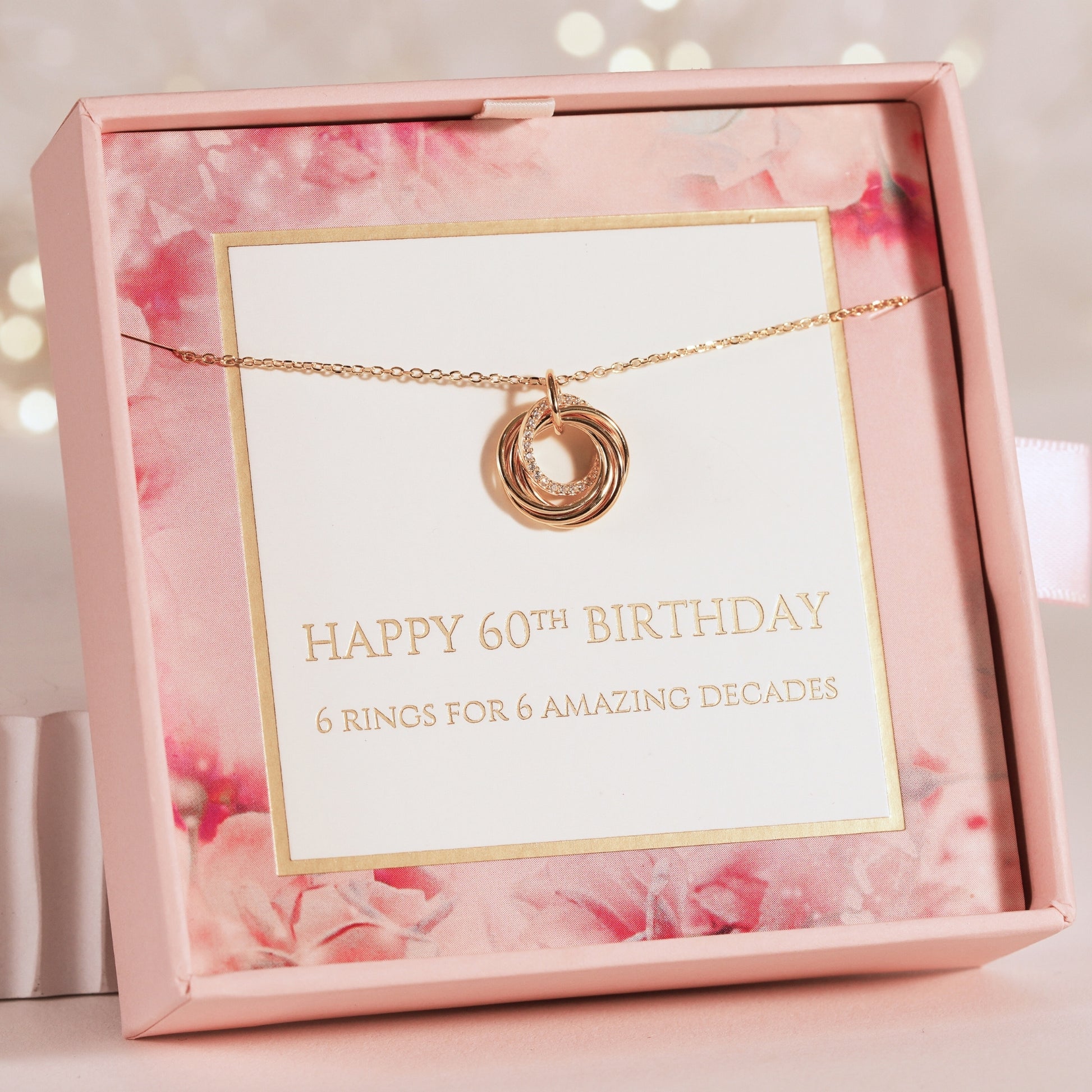 Rose gold necklace with a card in a pink floral box, celebrating a 60th birthday.