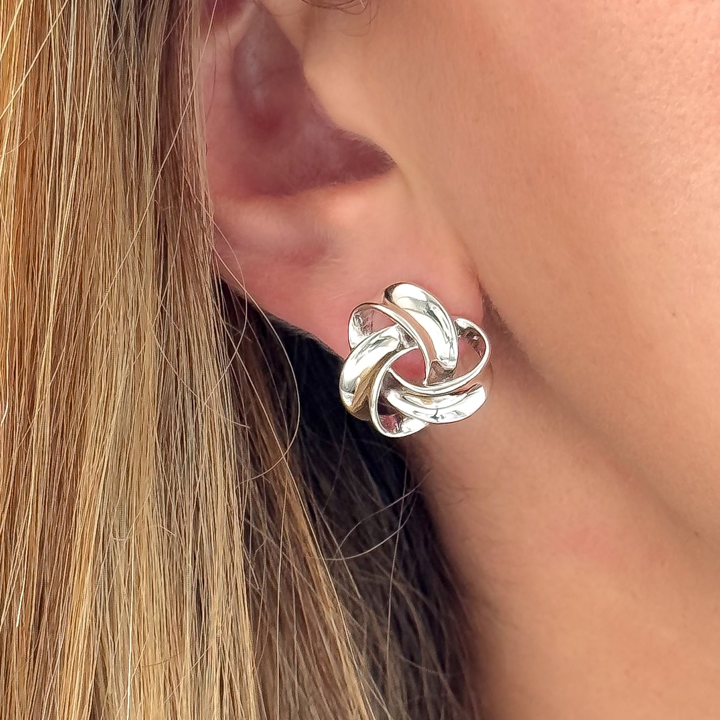 Chunky sterling silver knot stud earrings with polished twist design