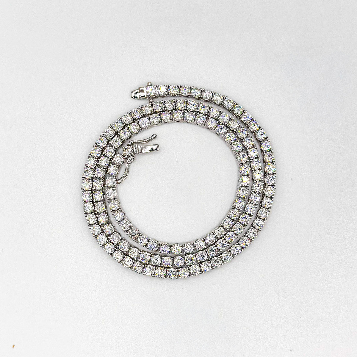 Moissanite tennis necklace coiled in a round shape with round stone settings