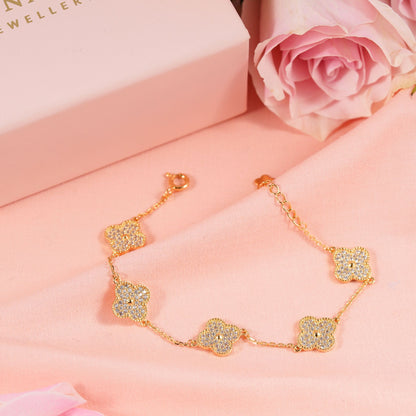 Gold clover bracelet with five shimmering clover charms on a fine chain.