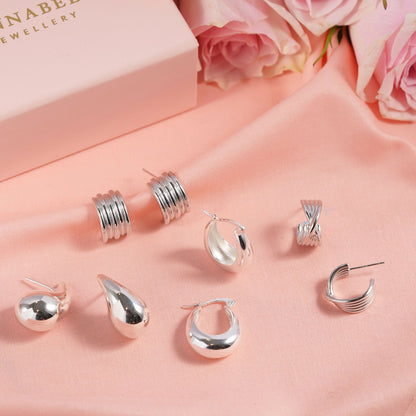 Assorted silver statement earrings, including teardrop drops and small studs