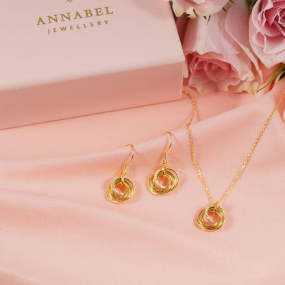 Gold hoop-style earrings with layered ring swirl drops