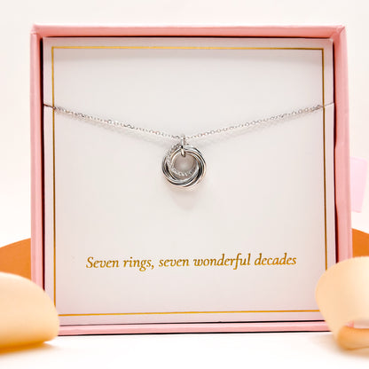 Silver 70th birthday necklace with round 7-ring pendant laid in a gift box