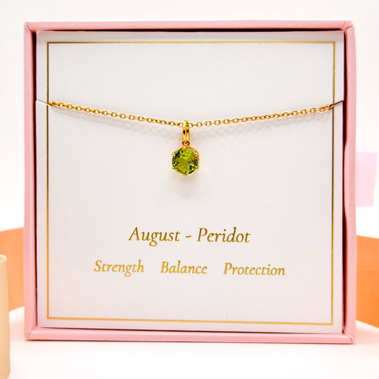 Gold-tone chain necklace with round green peridot-style gemstone pendant