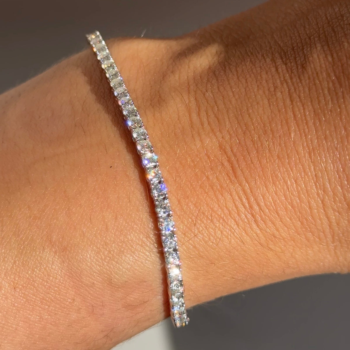 Moissanite tennis bracelet worn on wrist, sparkly row of round stones