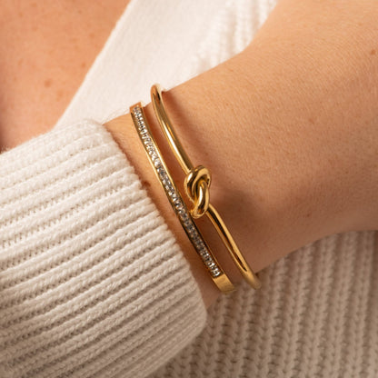 Gold knot bangle with pavé-set side bar and twisted knot detail