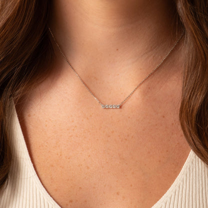 Bar necklace with row of small crystals set in a slim rectangular pendant