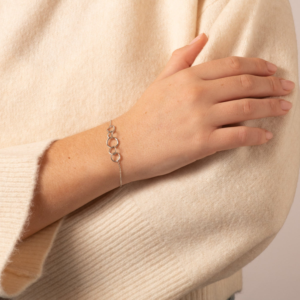 Gold-tone five-ring bracelet on wrist with small round hoop links