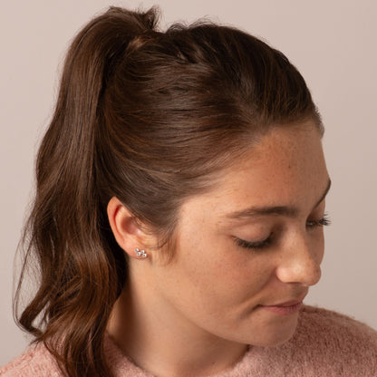 Diamond stud earrings with four small stones on a model’s ear