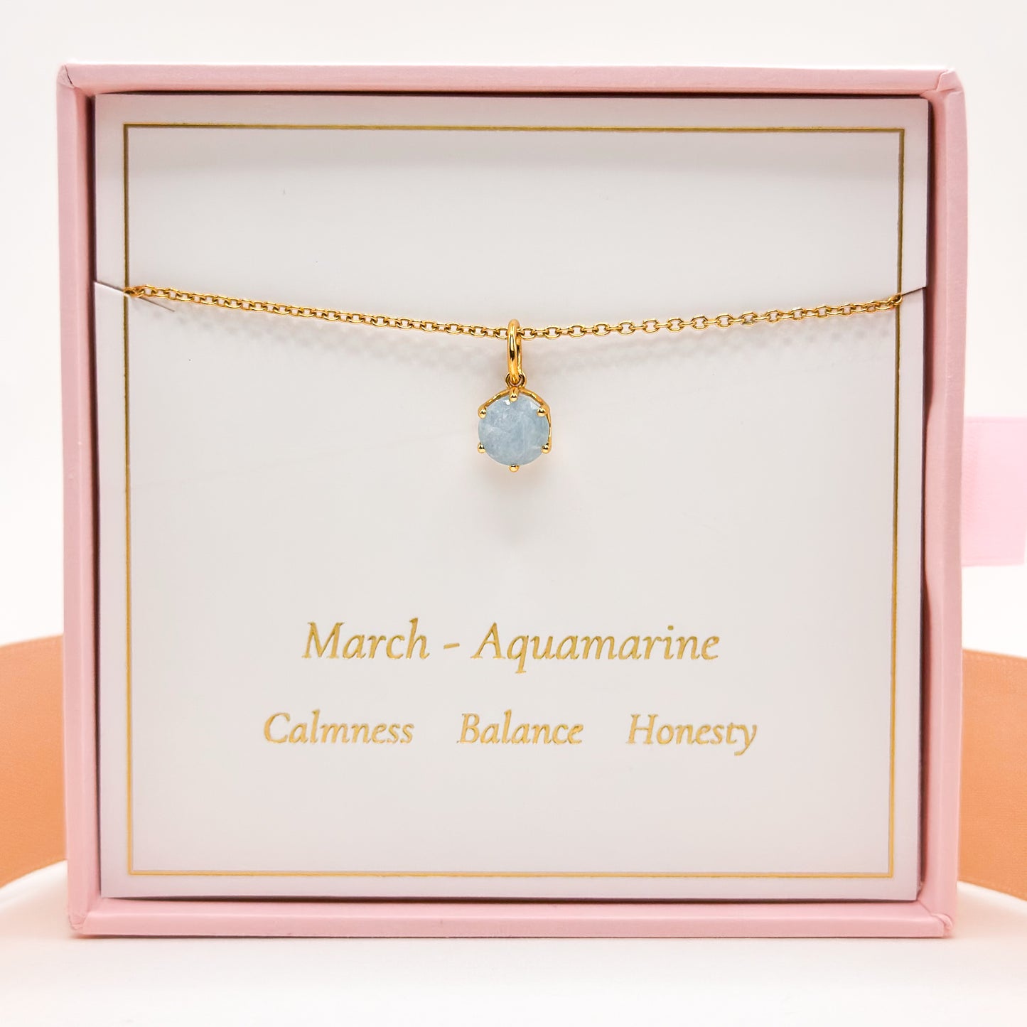 Gold necklace with round blue aquamarine pendant on fine chain