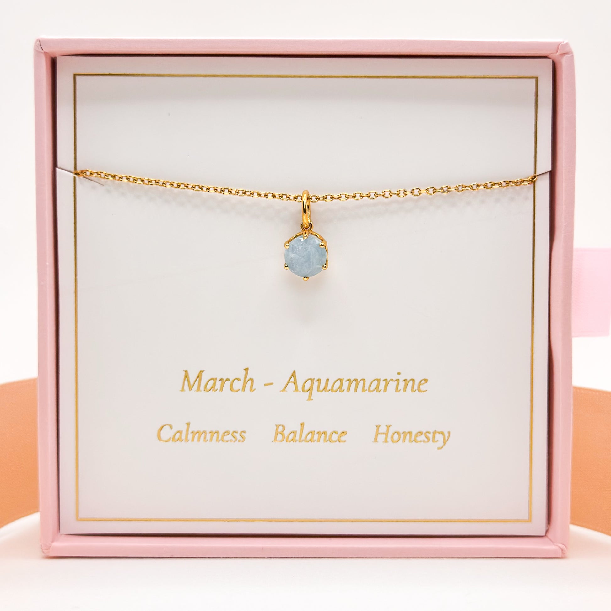 Gold necklace with round blue aquamarine pendant on fine chain