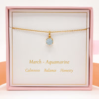 Gold necklace with round blue aquamarine pendant on fine chain