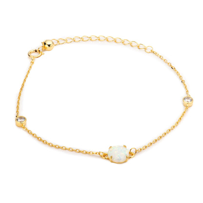 Gold chain bracelet with round opal-like center charm and two small bezel stones