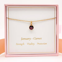 Gold necklace with small round red garnet pendant and fine chain
