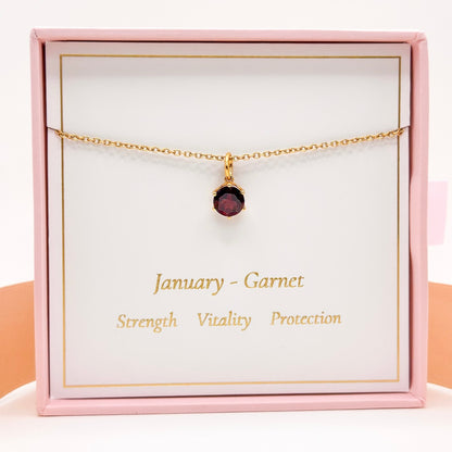 Gold necklace with small round red garnet pendant and fine chain