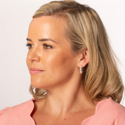Gold chunky hoop earrings on model, thick oval hoops
