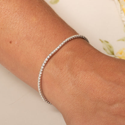 Silver tennis bracelet with round pave stones, worn on wrist