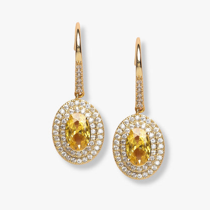 Gold drop earrings with oval yellow gemstone and diamond-style halo, teardrop setting