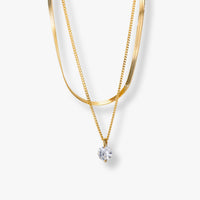 Double-layer necklace showing gold-tone snake chains and dangling round crystal charm