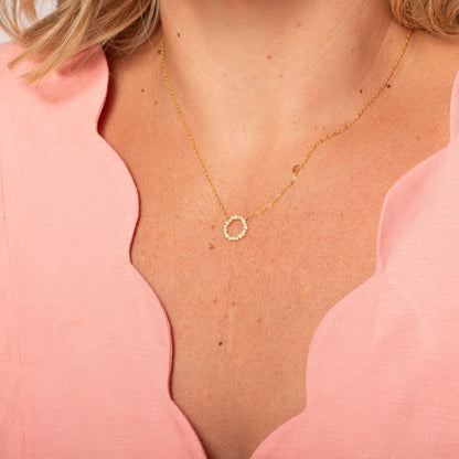 Gold circle pendant necklace with a small round ring pendant
