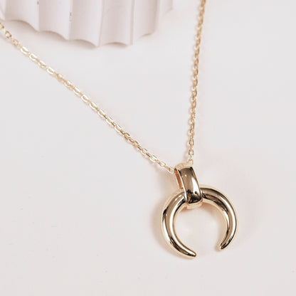 Gold-toned crescent moon pendant with top bail on chain