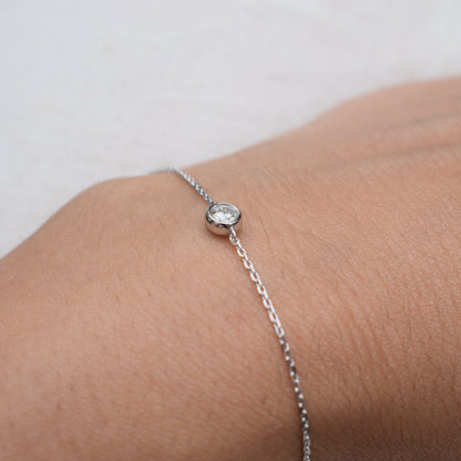 Close-up moissanite bracelet with round bezel-set stone on silver chain