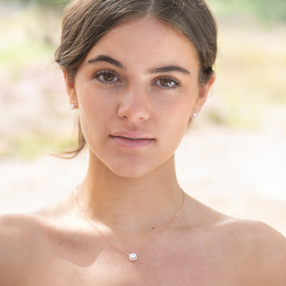 Square crystal pendant necklace with thin chain, worn at the collar