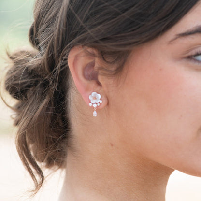 Enamel flower earrings with pearl accents and crystal drop dangle on ear