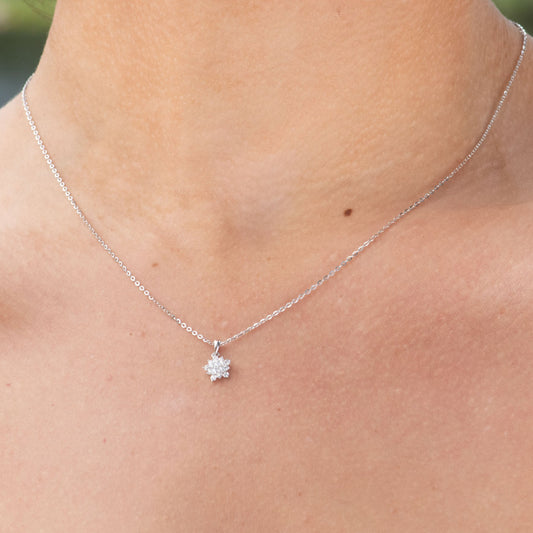 Necklace with a small pendant worn by a person outdoors