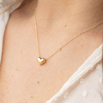 Gold heart pendant necklace with small heart charm on thin chain